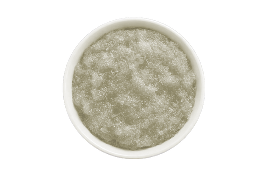 White bowl filled with a greenish-brown scrub on a white background