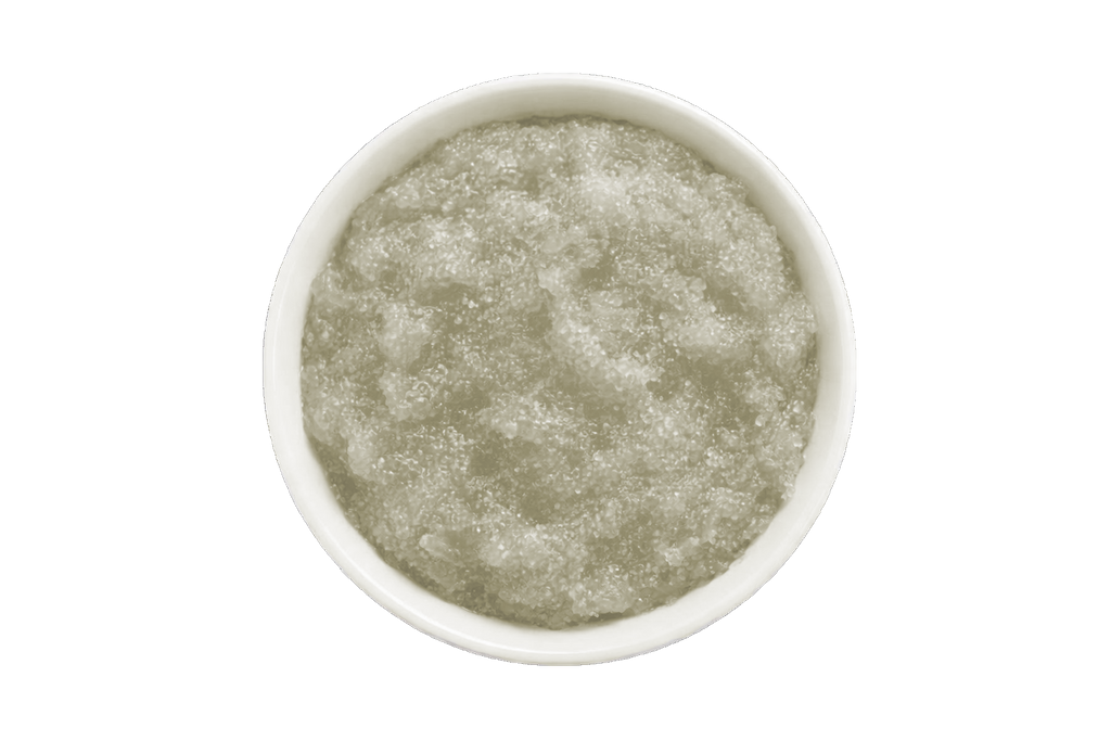 White bowl filled with a greenish-brown scrub on a white background