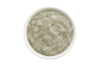 White bowl filled with a greenish-brown scrub on a white background