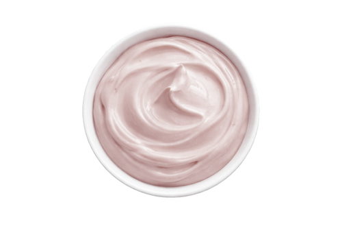 White cream in a small bowl on a white background