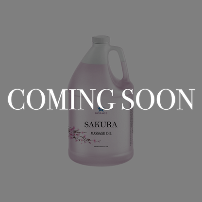A large plastic jug of Sakura Massage Oil by BioRange on a solid gray background, overlaid with a large white 'COMING SOON' text banner.
